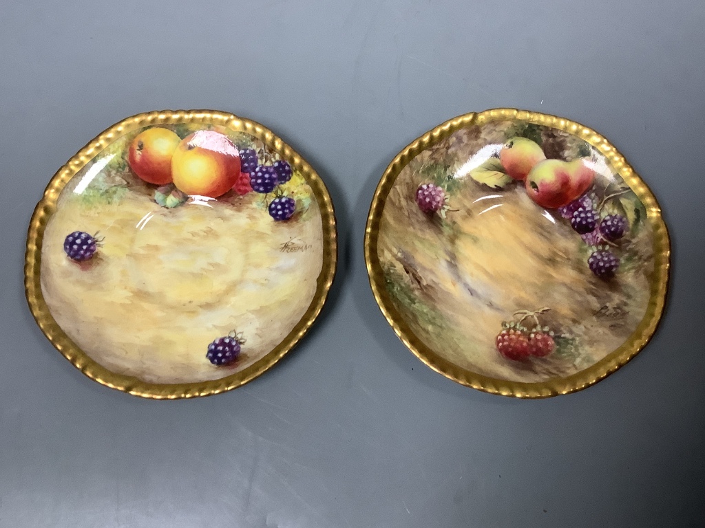 A pair of Royal Worcester fruit painted coffee cups and saucers, signed Freeman, (one saucer signed P. Love) 11cm